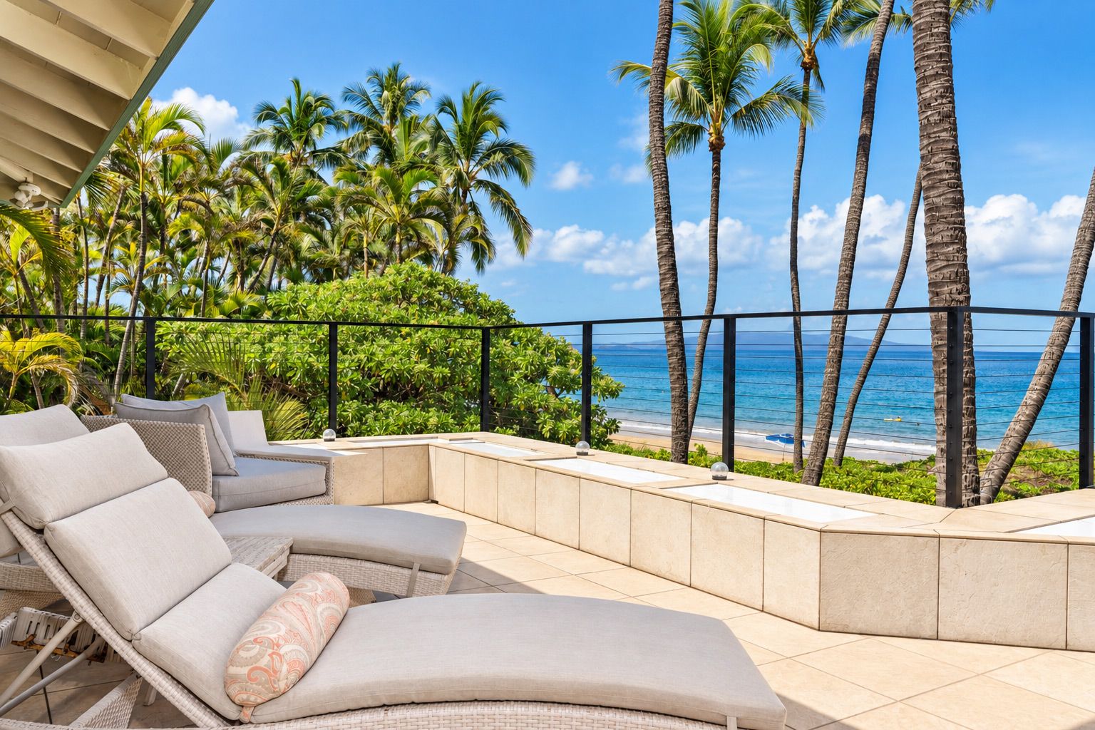 Oceanfront lanai with lounge chairs, palms, and ocean views